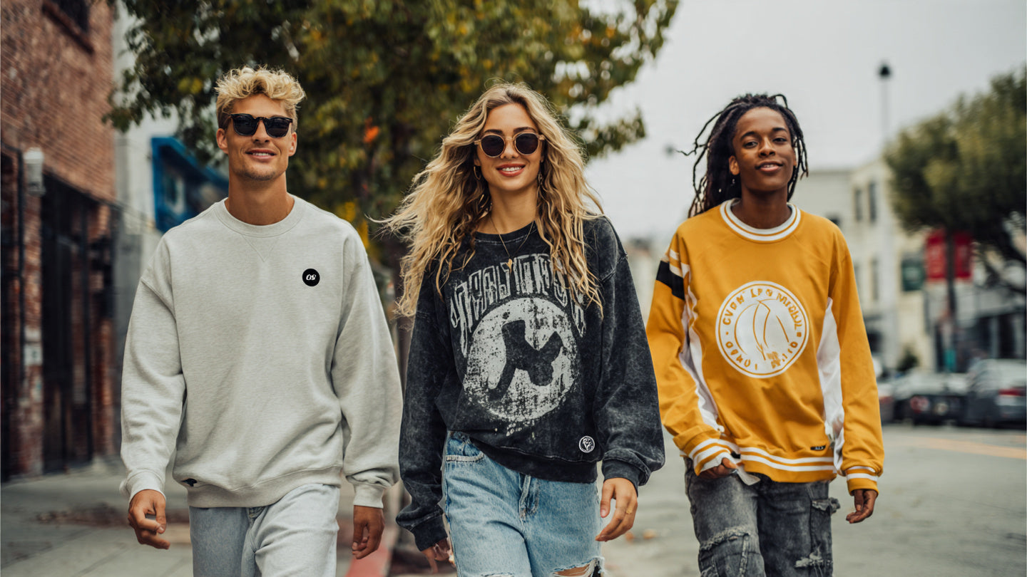 Three people wearing different graphic and branded sweatshirts walking together on a city street.